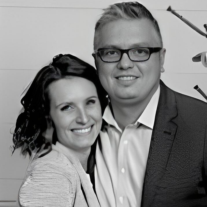 Smiling couple posing together in black and white.